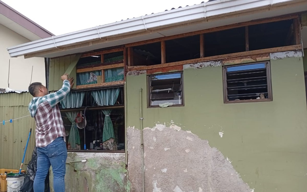 Fachada antes: repello dañado, madera expuesta y pintura deteriorada